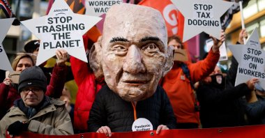 An activist from the Extinction Rebellion (XR) climate change group, wearing a mask depicting Jeff Bezos, takes part in a protest outside of Amazon's headquarters in central London, U.K., on Nov. 26, 2021. (AFP Photo)