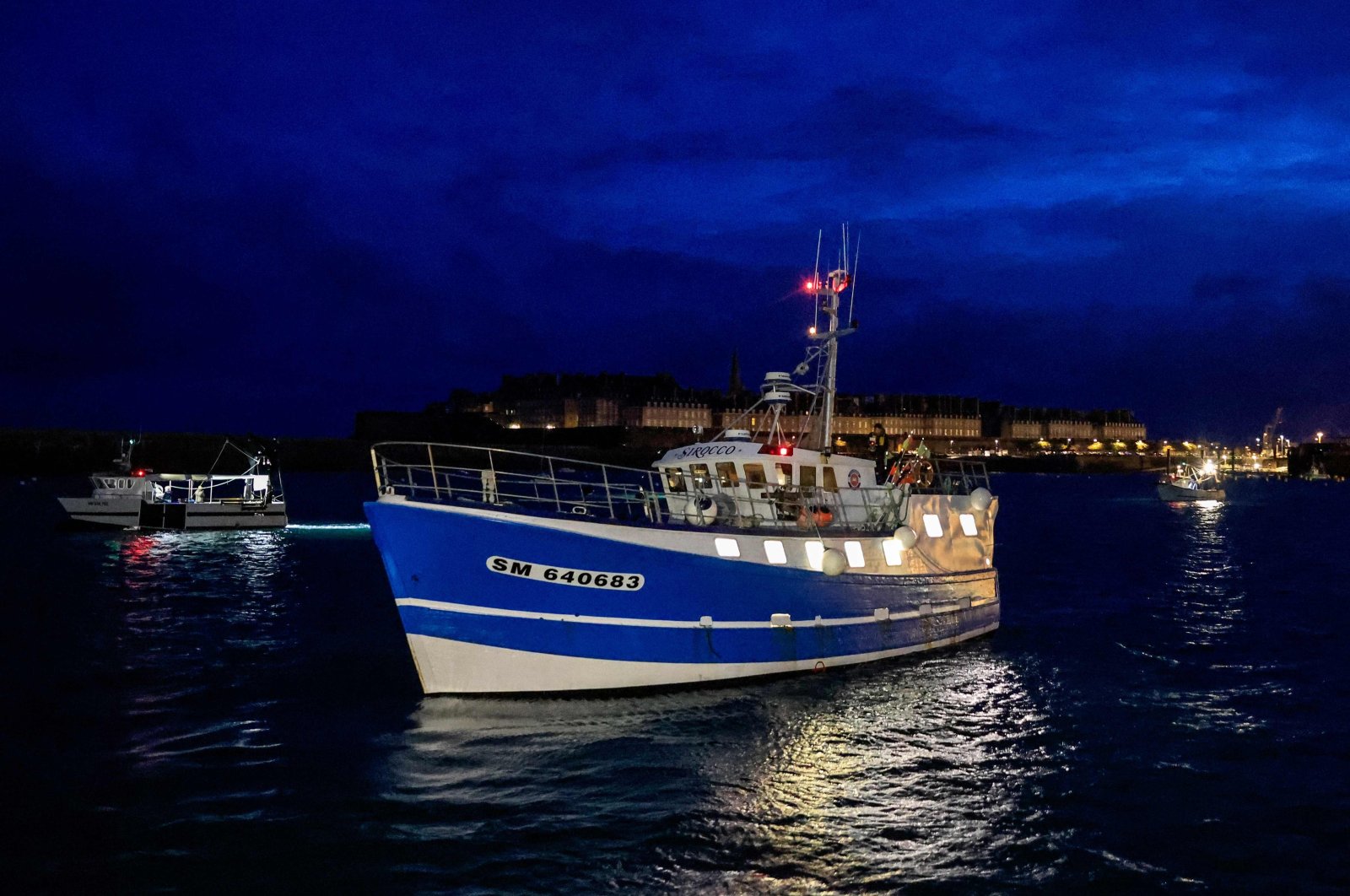 French fishing boats block the entrance to the port of Saint-Malo on Nov. 26, 2021 as fishermen planned to block ferry traffic into two other Channel ports and the movement of goods through the rail tunnel between France and the U.K. in protest over post-Brexit fishing rights. (AFP Photo)