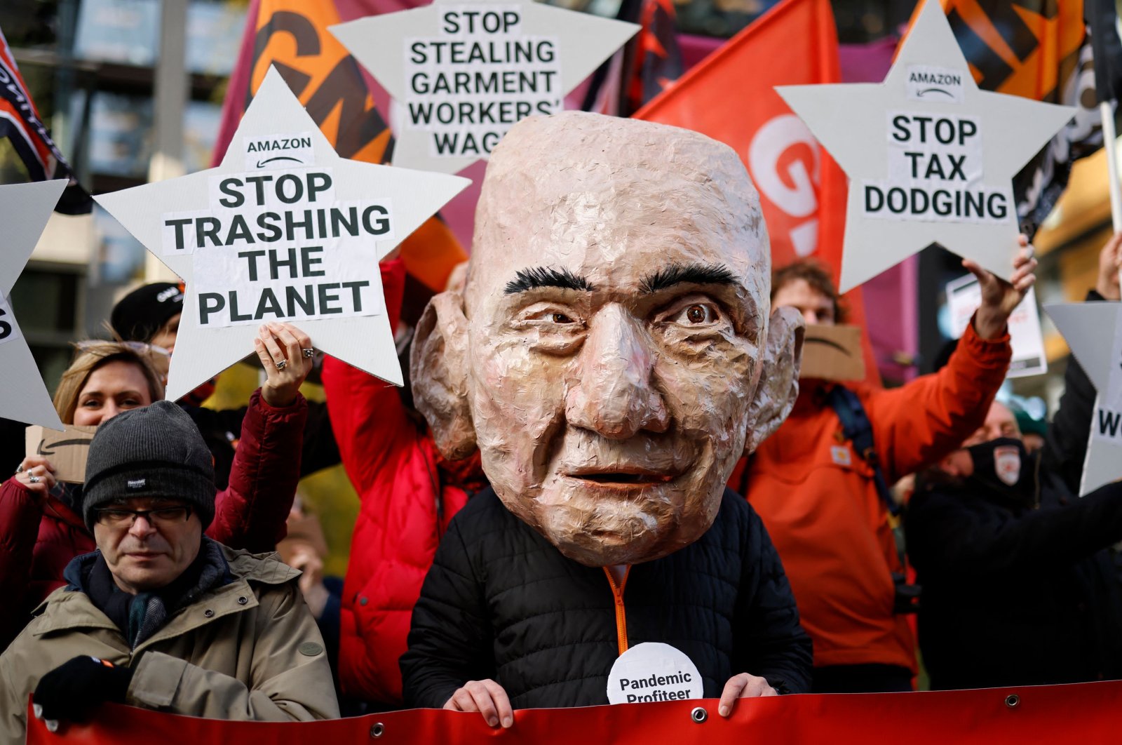 An activist from the Extinction Rebellion (XR) climate change group, wearing a mask depicting Jeff Bezos, takes part in a protest outside of Amazon&#039;s headquarters in central London, U.K., on Nov. 26, 2021. (AFP Photo)