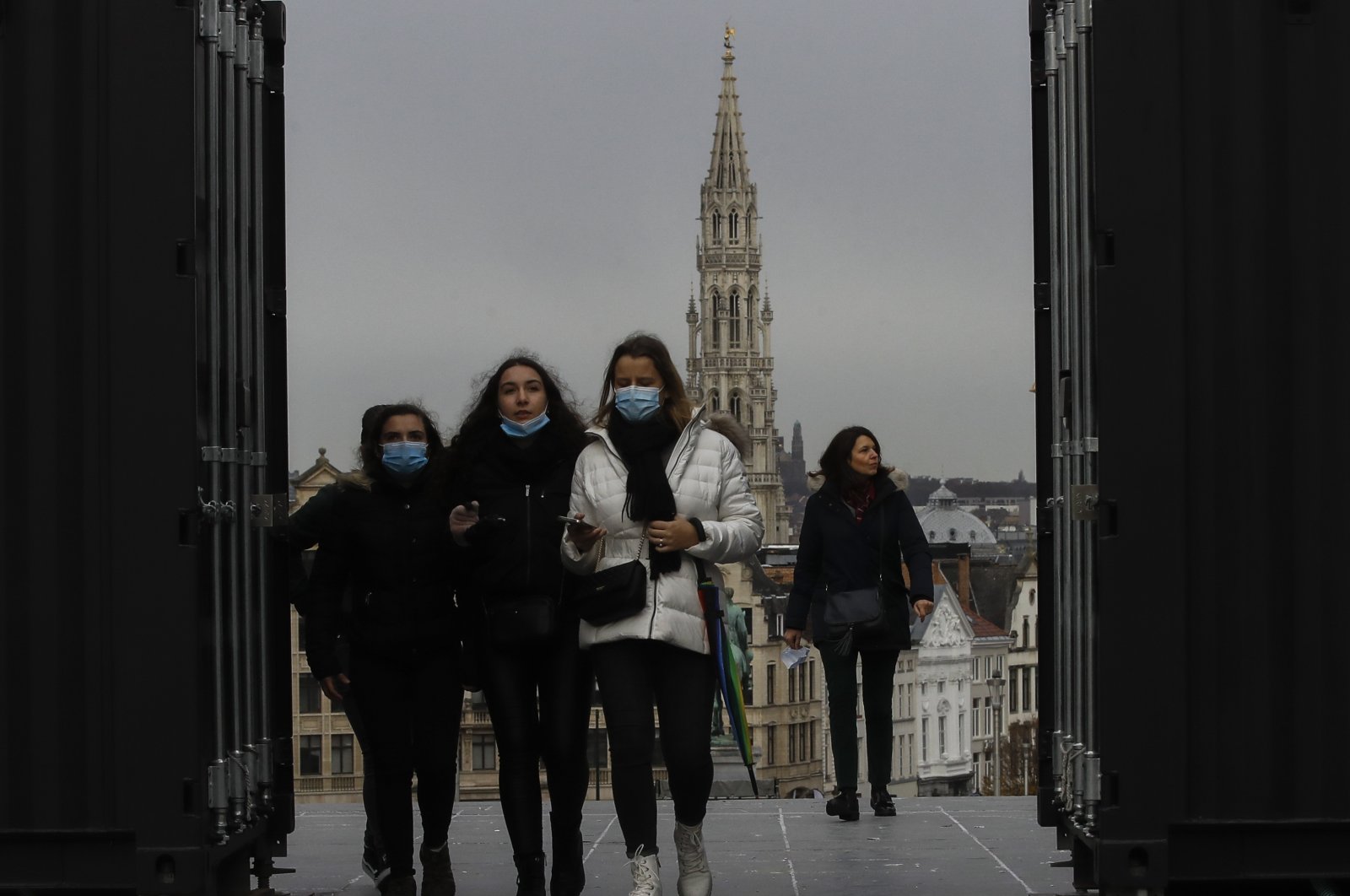 A group of pedestrians, some wearing protective face masks, walk in the city as members of the Belgian government gather to impose new restrictions to curb the spread of the coronavirus pandemic, in Brussels, Belgium, Nov. 16, 2021. (EPA Photo)