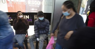 Shoppers wearing face masks on a crowded sidewalk in Pretoria, South Africa, Nov. 27, 2021. (AP Photo)