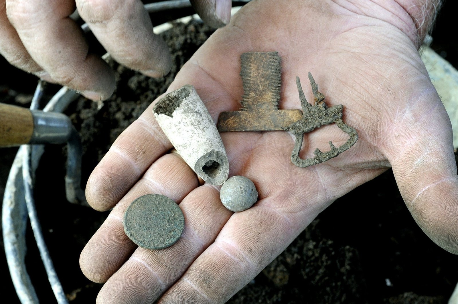 A similar historical coin (Bottom-L) from around the same period in the U.S. seen with other items archaeologists found at a dig site at Colonial Pemaquid State Historic Site, Bristol, Maine, U.S, July 25, 2013. (Portland Press Herald via Getty Images)