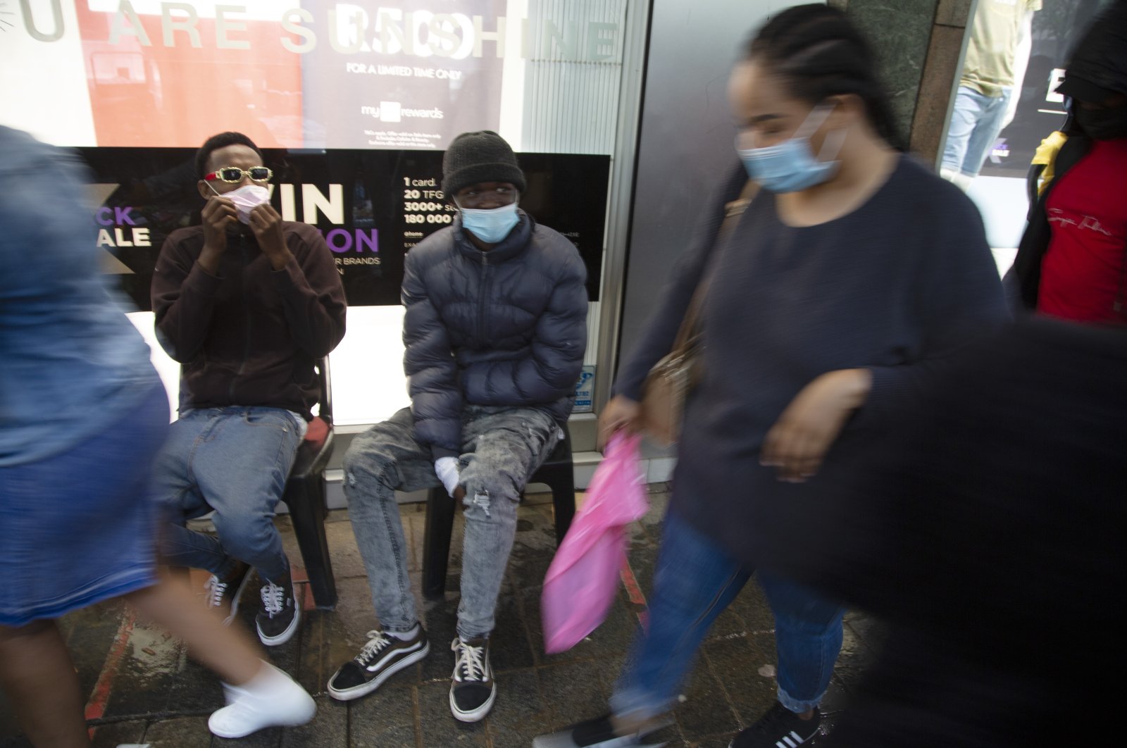 Shoppers wearing face masks on a crowded sidewalk in Pretoria, South Africa, Nov. 27, 2021. (AP Photo)