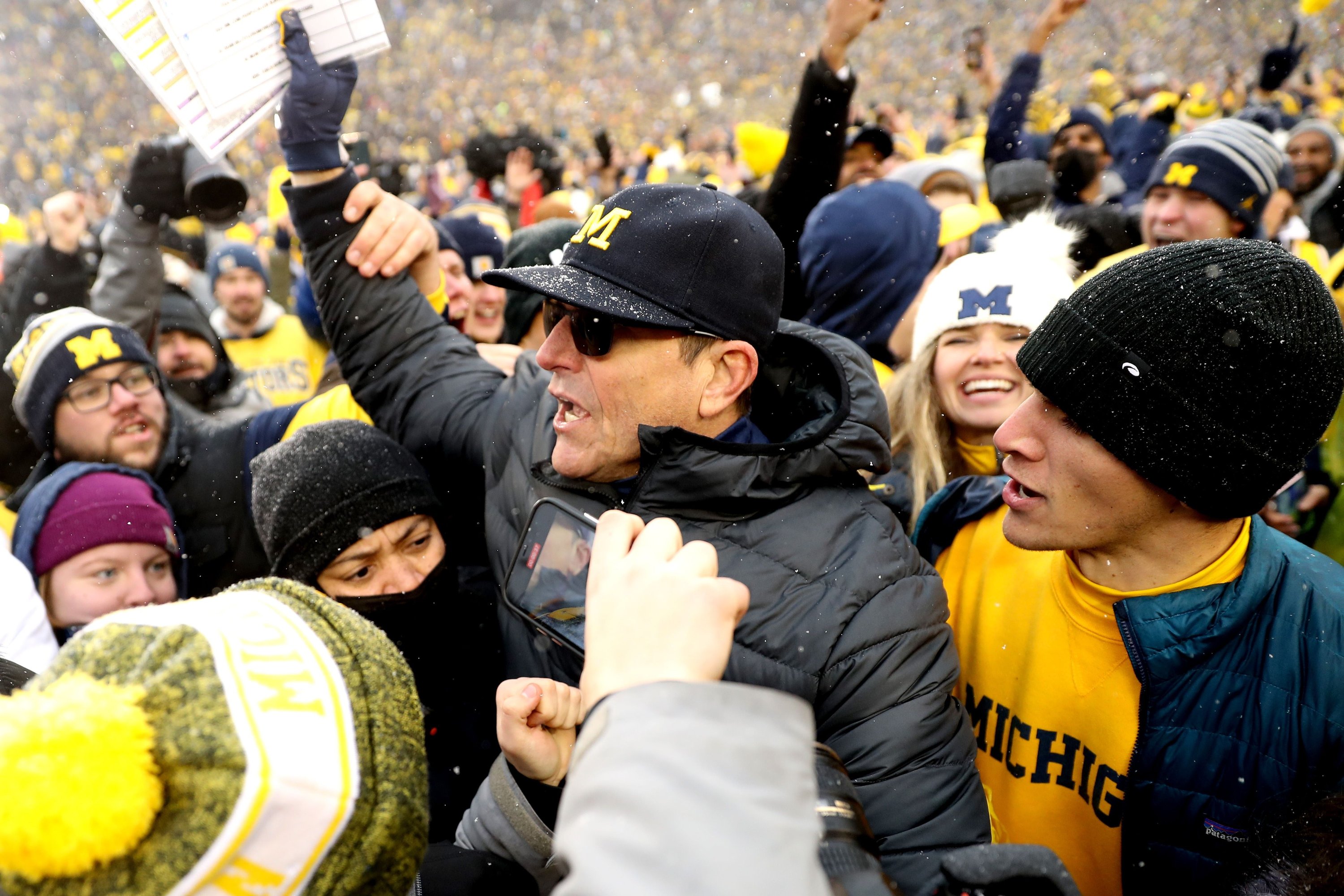 Head Coach Jim Harbaugh of the Michigan Wolverines celebrates with fans after defeating the Ohio State Buckeyes at Michigan Stadium, Ann Arbor, Michigan, U.S., Nov. 27, 2021. (AFP Photo)