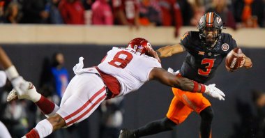 Quarterback Spencer Sanders (3) of the Oklahoma State Cowboys dodges defensive lineman Perrion Winfrey (8) of the Oklahoma Sooners in the fourth quarter at Boone Pickens Stadium, Stillwater, Oklahoma, U.S., Nov. 27, 2021. (AFP Photo)