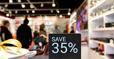 People walk around a shop while a discount sign is seen outside as Black Friday sales begin at The Outlet Shoppes of the Bluegrass in Simpsonville, Kentucky, U.S., Nov. 26, 2021. (Reuters Photo)