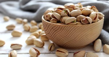 Pistachios nuts in a wooden bowl.