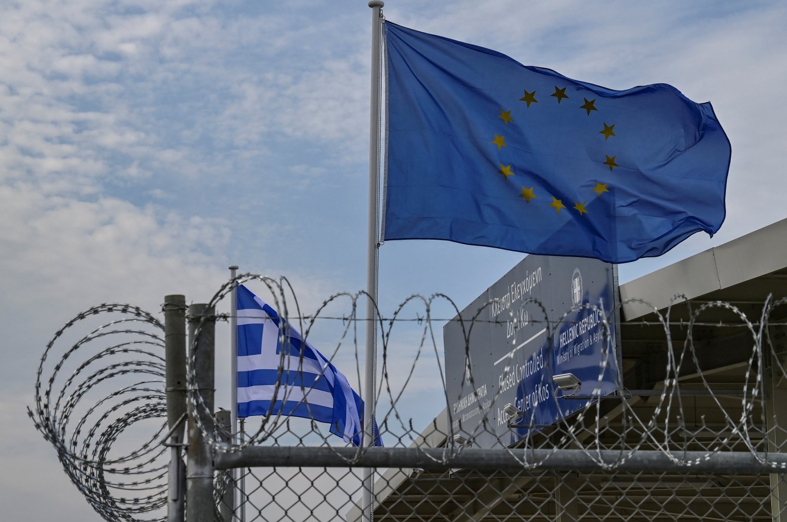 The European flag waves behind barbed wires at the new &quot;closed&quot; center for migrants in the Greek island of Kos, Greece, Nov. 27, 2021. (AFP Photo)