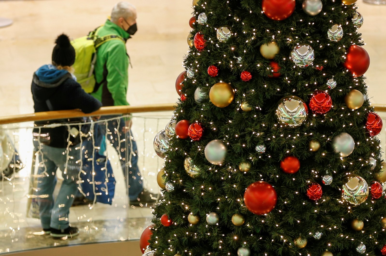 People move past a Christmas tree in a shopping center as a fourth wave of the coronavirus pandemic hits, Munich, Germany, Nov. 27, 2021. (Reuters Photo)