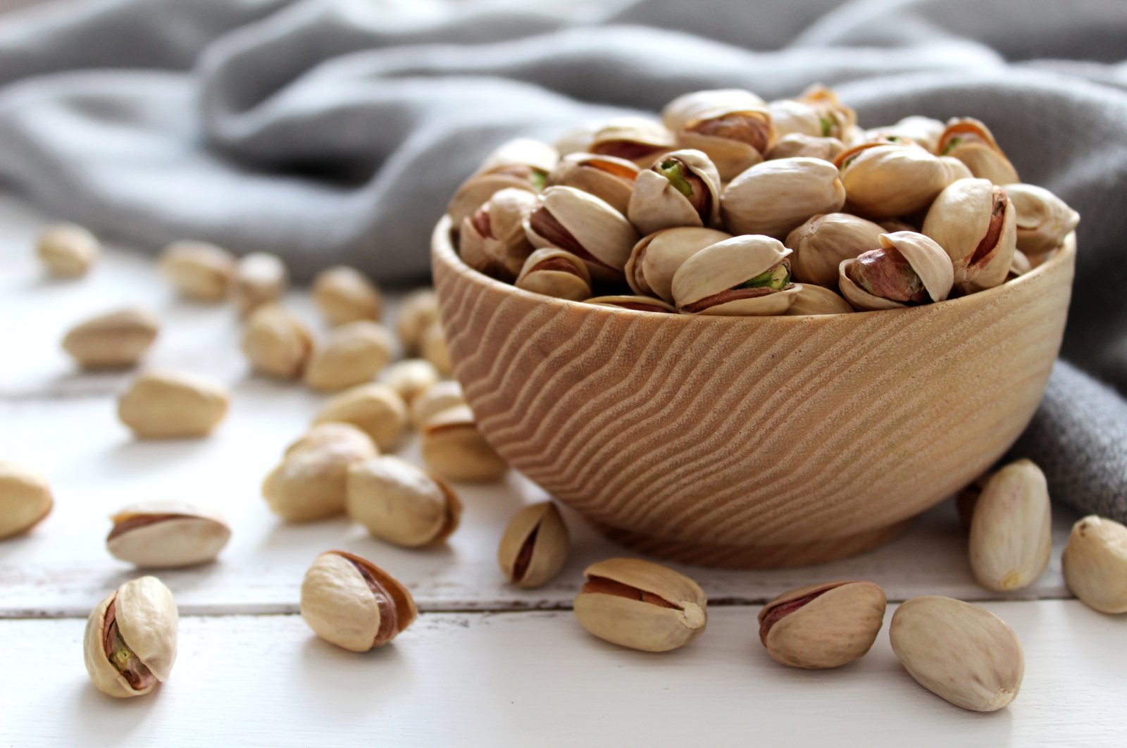 Pistachios nuts in a wooden bowl.