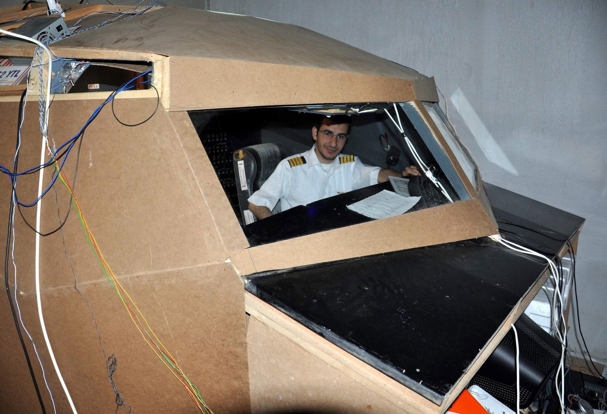 Aviation-lover Alihan Kolaylı seen in front of the Boeing 737-800 airplane cockpit he created in his basement 10 years ago, in Trabzon, Turkey, Nov. 29, 2021. (IHA Photo)
