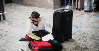 A passenger tries to find a flight as several airlines have stopped flying out of South Africa, amid the spread of the new SARS-CoV-2 variant omicron, at O.R. Tambo International Airport in Johannesburg, South Africa, Nov. 28, 2021. (Reuters Photo)