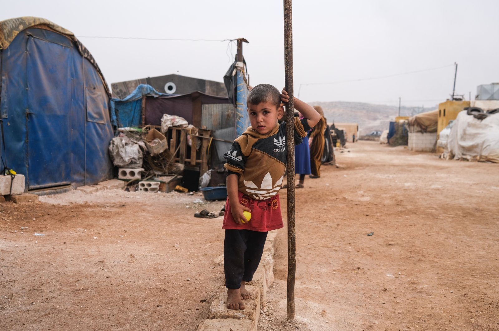 A displaced Syrian boy looks on while standing in front of his tent at Gemmura camp in Sarmada district, on the outskirts of Idlib, Syria, Nov. 25, 2021 (EPA Photo)