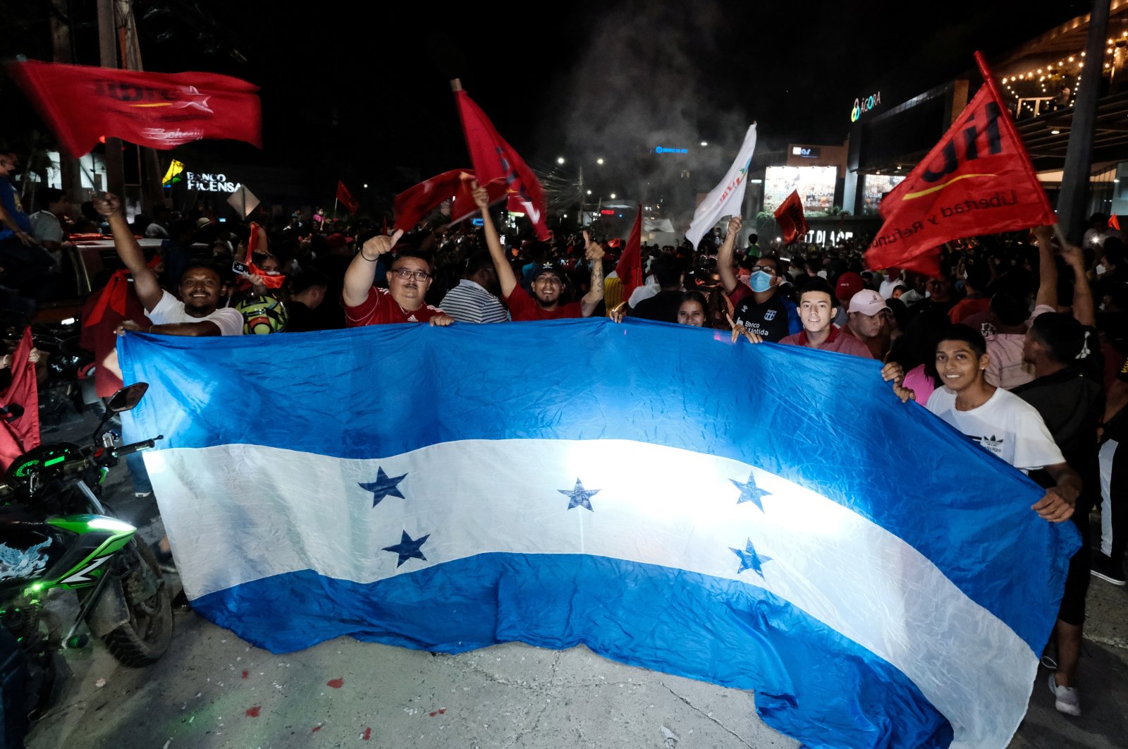 Supporters of the Liberty and Refoundation Party (LIBRE) hold an oversized flag of Honduras after the closing of the general election, in San Pedro Sula, Honduras, Nov. 28, 2021. (Reuters Photo)