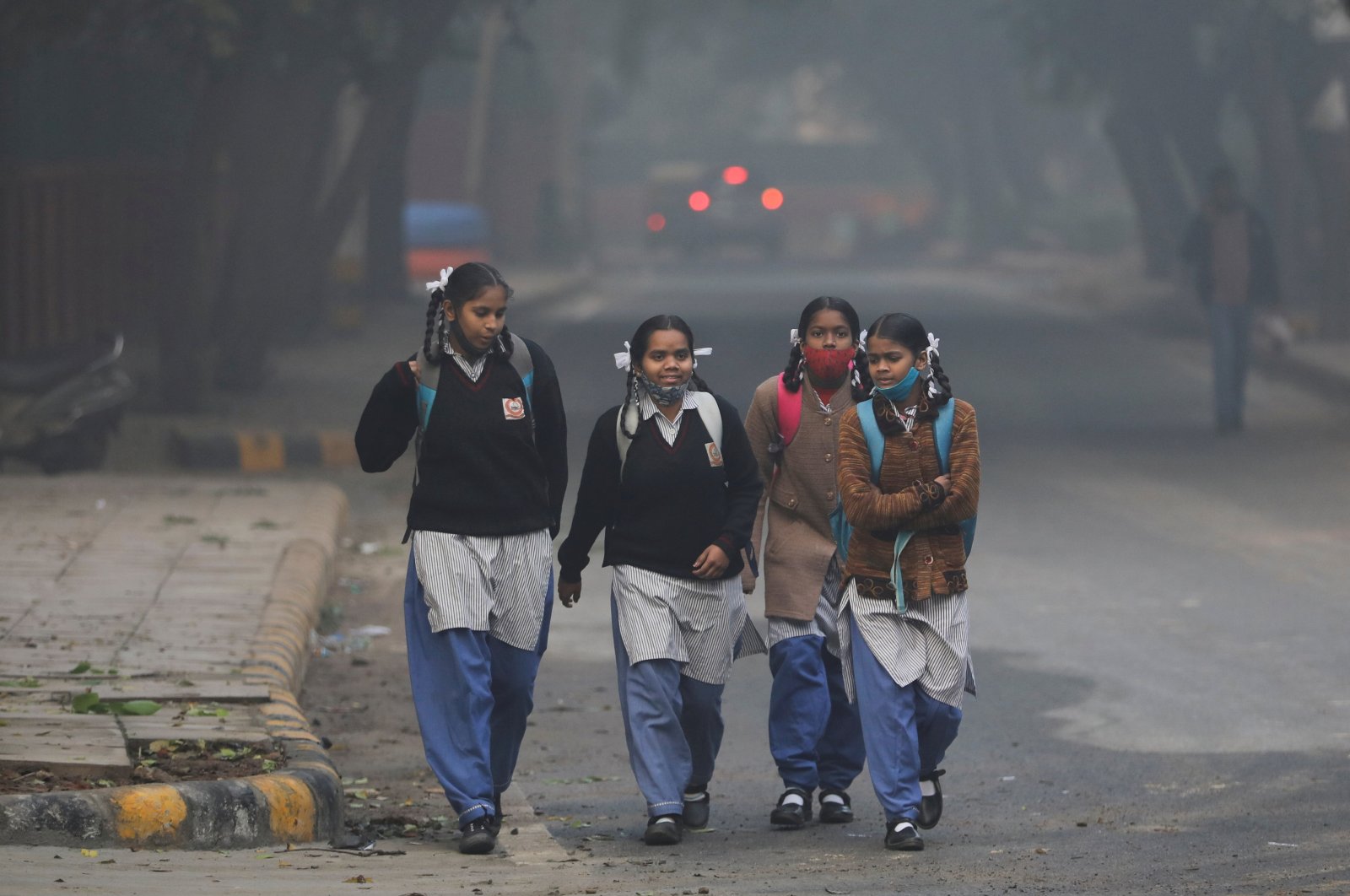 On a smoggy morning, girls walk to their school as they reopen after 15 days of closure due to a spike in air pollution, New Delhi, India, Nov. 29, 2021. (Reuters Photo)