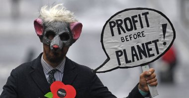 A demonstrator holds a placard as he attends a protest rally during a global day of action on climate change in Glasgow, Scotland, Nov. 6, 2021. (AFP Photo)