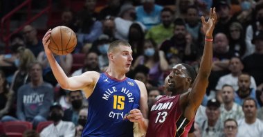 Denver Nuggets center Nikola Jokic (L) passes past Miami Heat center Bam Adebayo during an NBA basketball game, Miami, U.S., Nov. 29, 2021. (AP Photo)