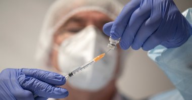 A doctor draws the BioNTech vaccine Comirnaty into a syringe in Kirn, Germany, Nov. 28, 2021. (AP Photo)