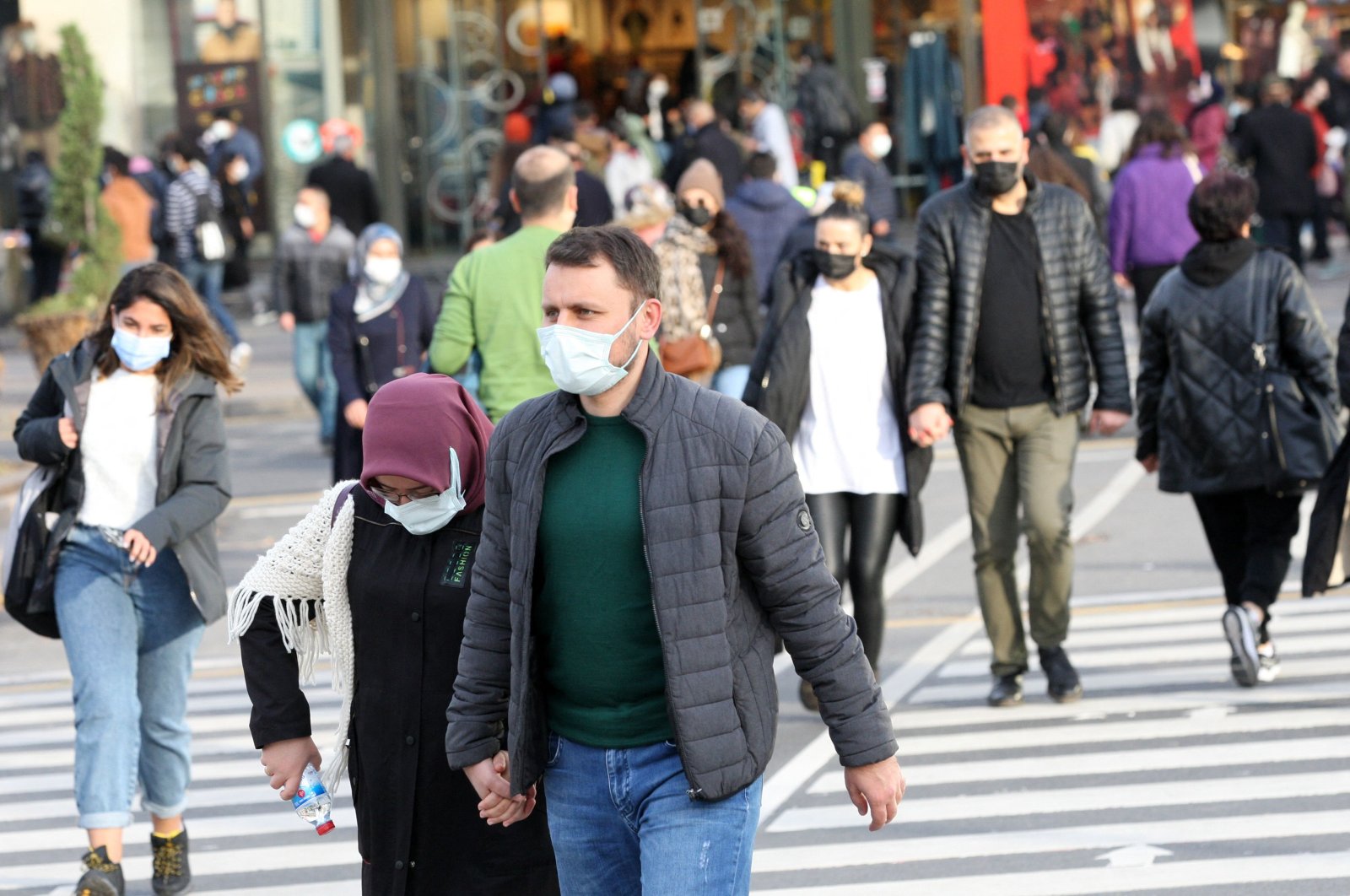 Pedestrians wearing masks walk on the street, in the capital Ankara, Turkey, Nov. 28, 2021. (AFP Photo)
