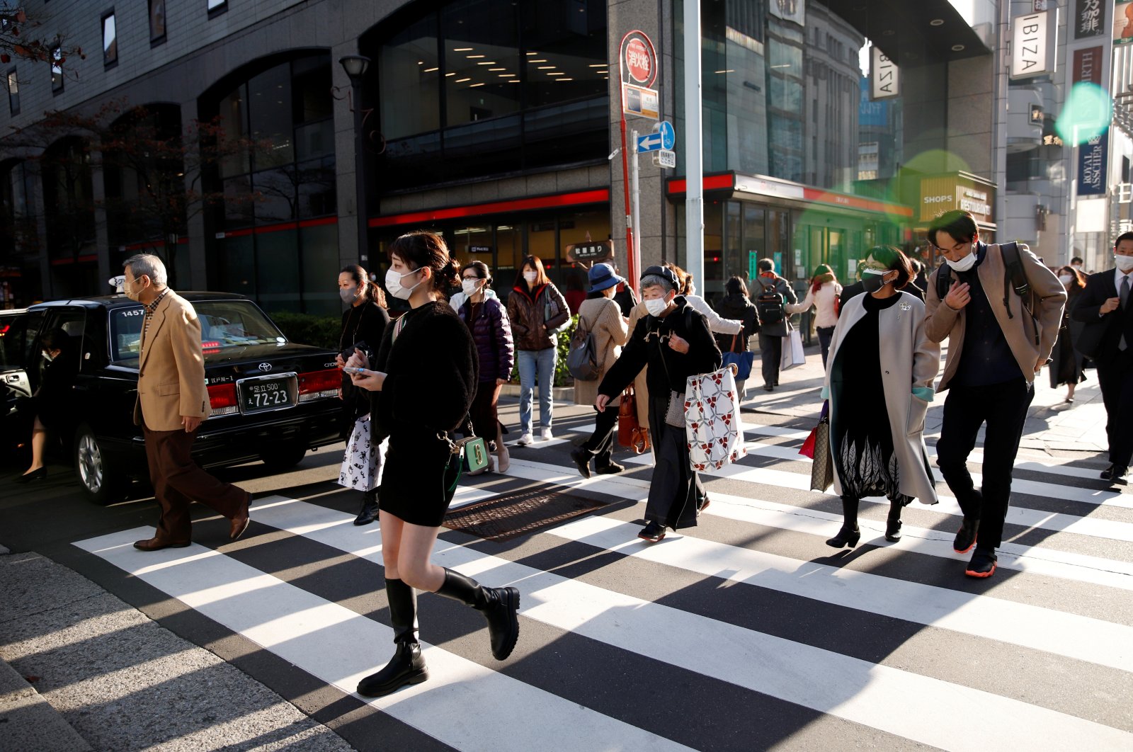 People cross the street in the Ginza shopping area, on the first day of Japan&#039;s closed borders to prevent the spread of the omicron variant of the coronavirus, in Tokyo, Japan, Nov. 30, 2021. (Reuters Photo)