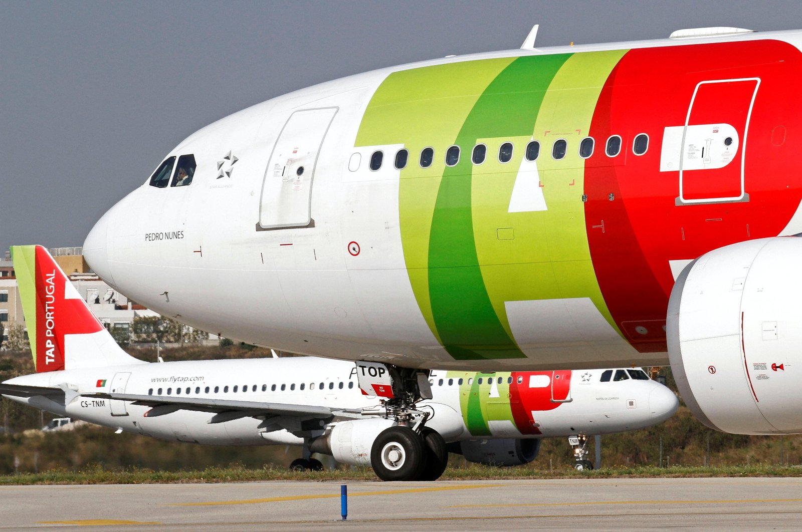 A TAP Air Portugal Airbus 320 aircraft maneuvers behind another TAP Airbus 330 at Lisbon airport, Portugal, March 29, 2012. (Reuters Photo)