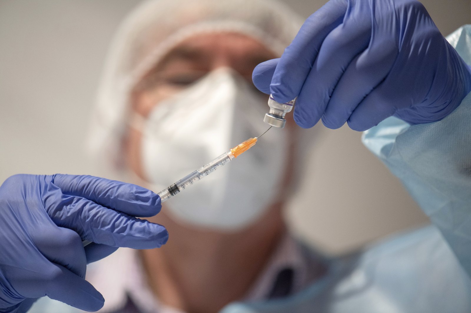 A doctor draws the BioNTech vaccine Comirnaty into a syringe in Kirn, Germany, Nov. 28, 2021. (AP Photo)