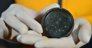 Ersin Çelikbaş shows the steelyard weight found in the ancient city of Hadrianopolis, Karabük, northern Turkey, Nov. 30, 2021. (AA Photo)