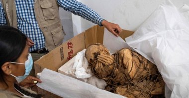 Archaeologist Pieter Van Dalen Luna (L), head responsible for the Cajamarquilla Archeological project shows, next to archaeologist Yomira Huamán, a mummy estimated to be between 800 and 1,200 years old, Lima, Peru, Nov. 30, 2021. (AFP Photo) 