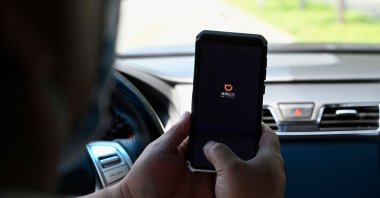 A driver opens the Didi Chuxing ride-hailing app on his smartphone in Beijing, China, July 2, 2021. (AFP Photo)