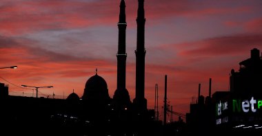 The sun sets behind the Sheikh Zayed Mosque in al-Azariya on the outskirts of Jerusalem on Nov. 30, 2021. (AFP Photo)