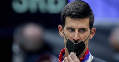 Serbia's Novak Djokovic wears a face mask as he listens prior to a Davis Cup match against Austria, Innsbruck, Austria, Nov. 26, 2021. (AP Photo)