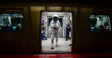 A man in an astronaut suit is seen inside the metro, Istanbul, Turkey, Dec. 1, 2021. (İHA Photo)
