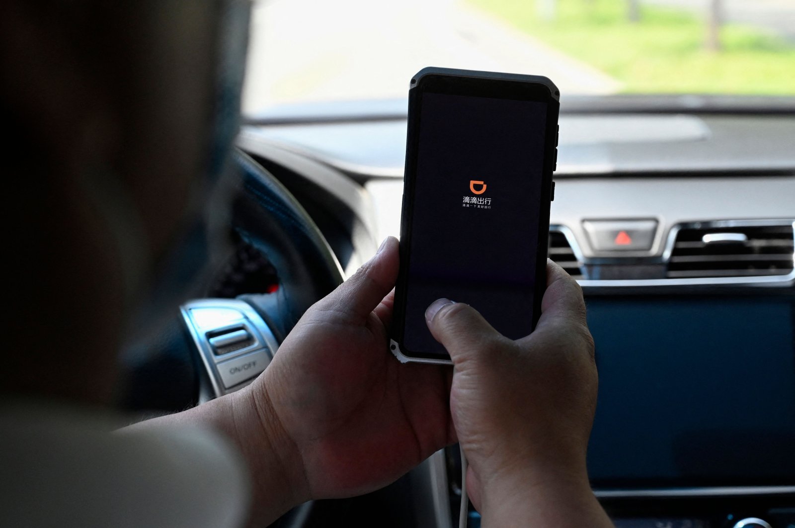 A driver opens the Didi Chuxing ride-hailing app on his smartphone in Beijing, China, July 2, 2021. (AFP Photo)