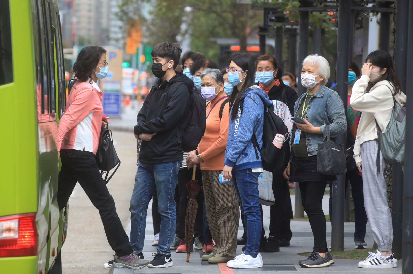 People wearing masks to prevent the spread of COVID-19 wait at a bus stop in Taipei, Taiwan, Nov. 30, 2021. (Reuters Photo)