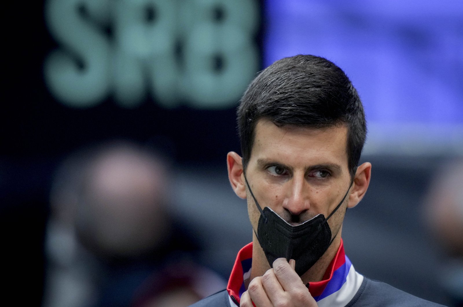 Serbia&#039;s Novak Djokovic wears a face mask as he listens prior to a Davis Cup match against Austria, Innsbruck, Austria, Nov. 26, 2021. (AP Photo)