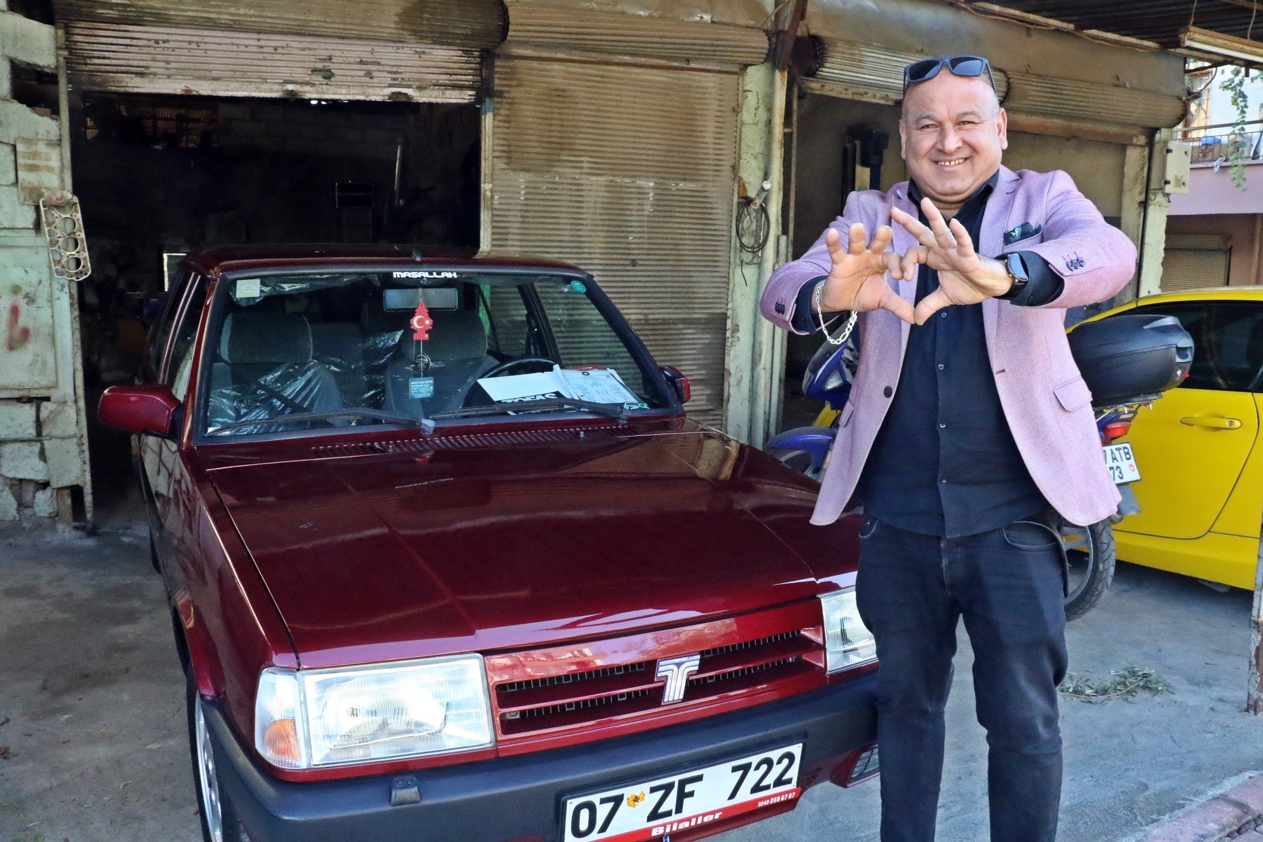 Abdullah imşek berdiri di samping Fiat-Tofaş Doğan SLX Model 2 burgundy 1994 miliknya, Antalya, Turki, Des.  1, 2021. (Foto IHA)