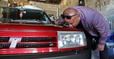 Abdullah Şimşek kisses his burgundy 1994 Fiat-Tofaş Doğan SLX Model 2 after being reunited with it, Antalya, Turkey, Dec. 1, 2021. (IHA Photo)