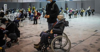A woman in a wheelchair waits to receive a dose of a COVID-19 vaccine, at the vaccination center of Parque das Nacoes, Lisbon, Portugal, Dec. 1, 2021. (AFP Photo)