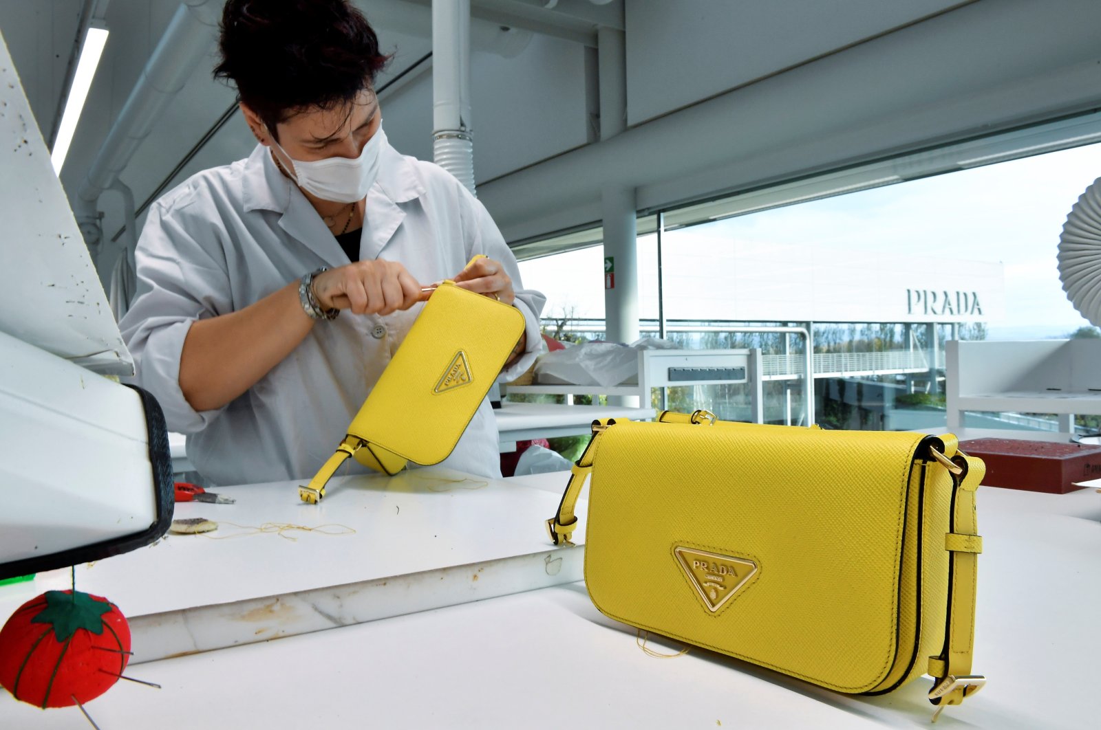 A staff member works on a handmade Prada bag at the Italian designer&#039;s industrial headquarters&#039; garden factory which hosts the production and development of Prada and Miu Miu&#039;s leather goods collections, in Valvigna Italy, Nov. 22, 2021. (Reuters Photo) 