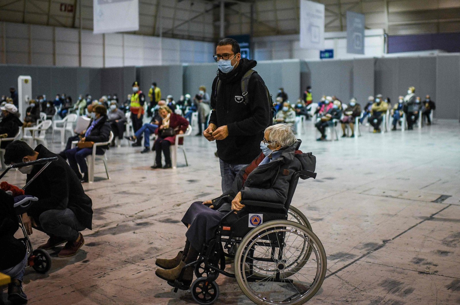 A woman in a wheelchair waits to receive a dose of a COVID-19 vaccine, at the vaccination center of Parque das Nacoes, Lisbon, Portugal, Dec. 1, 2021. (AFP Photo)