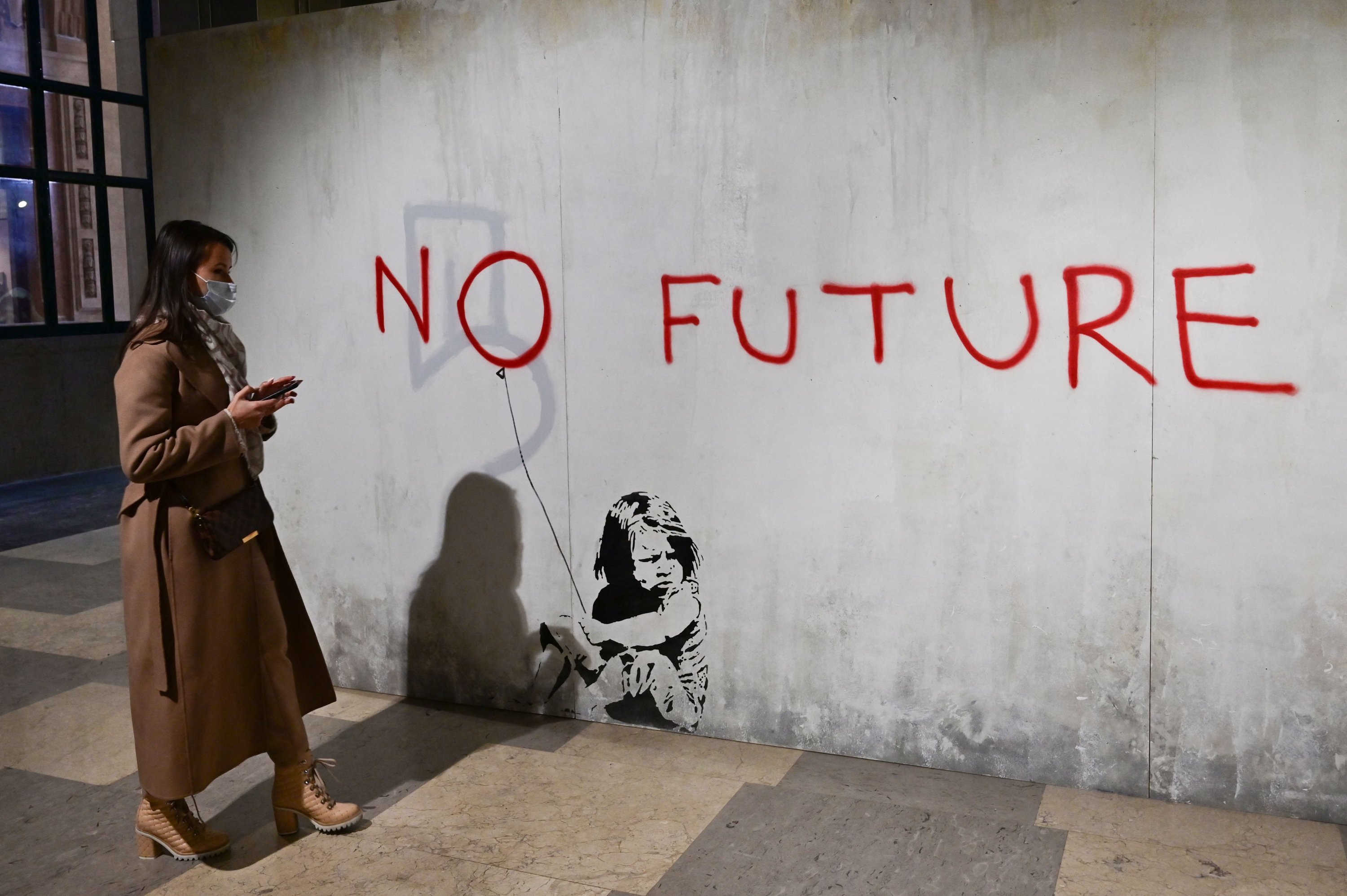 A woman looks at British street artist Banksy's mural 