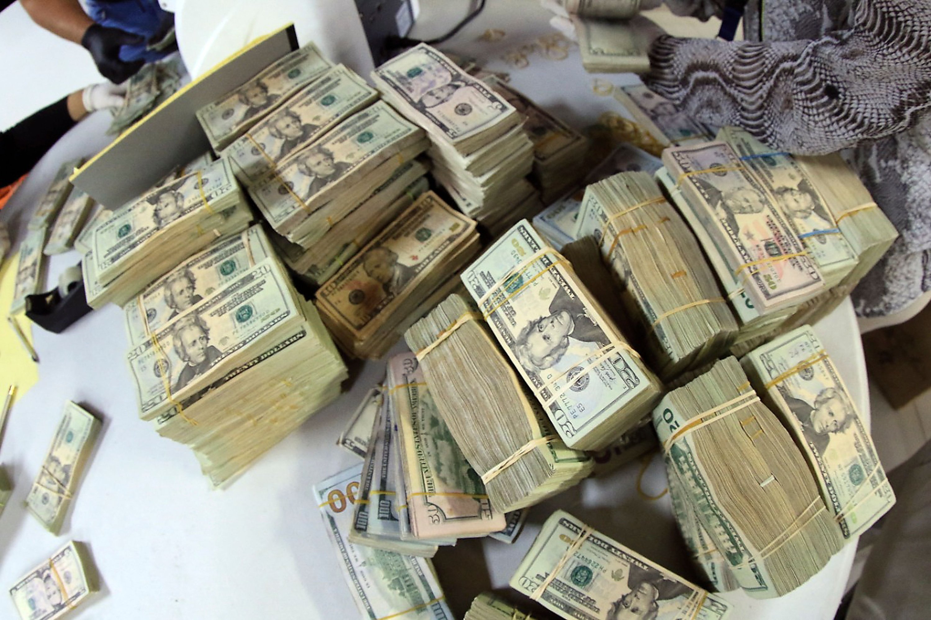 police personnel counting U.S. dollar bills seized from an alleged criminal group linked to Colombia's Clan del Golfo cartel, Colon, Panama, Dec. 2, 2021. (AFP Photo / Panama's National Police Press Office)