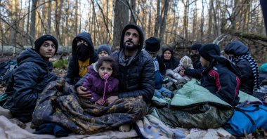 Members of a Kurdish family from Dohuk in Iraq are seen in a forest near the Polish-Belarus border while waiting for the border guard patrol, near Narewka, Poland, on Nov. 9, 2021. (AFP Photo)