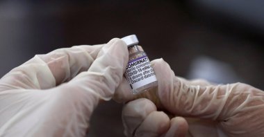 A health worker holds a vial of the "Comirnaty," Pfizer-BioNTech's COVID-19 vaccine at a vaccination center in Karachi, Pakistan, Dec. 2, 2021. (Reuters Photo)