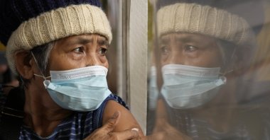 A woman holds onto a cotton pad after being inoculated with AstraZeneca&#039;s COVID-19 vaccine in Quezon city, Philippines, Nov. 29, 2021. (AP Photo)