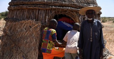 An elderly man stand in front of a storage building for millet in a village affected with an alimentary crisis, Ouallam area, Niger, on Nov. 13, 2021 (AFP Photo)