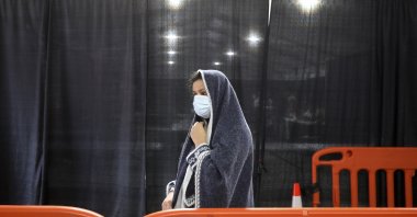 An Afghan refugee waits in line for personal hygiene products inside a distribution and donation center at Liberty Village on Joint Base McGuire-Dix-Lakehurst in Trenton, N.J., U.S., Dec. 2, 2021. (AP Photo)