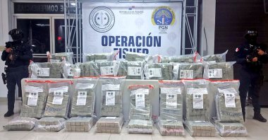 Police personnel guard packages of seized $10 million in U.S. dollar bills seized from an alleged criminal group linked to Colombia&#039;s Clan del Golfo cartel, Colon, Panama, Dec. 2, 2021. (AFP Photo / Panama&#039;s National Police Press Office)