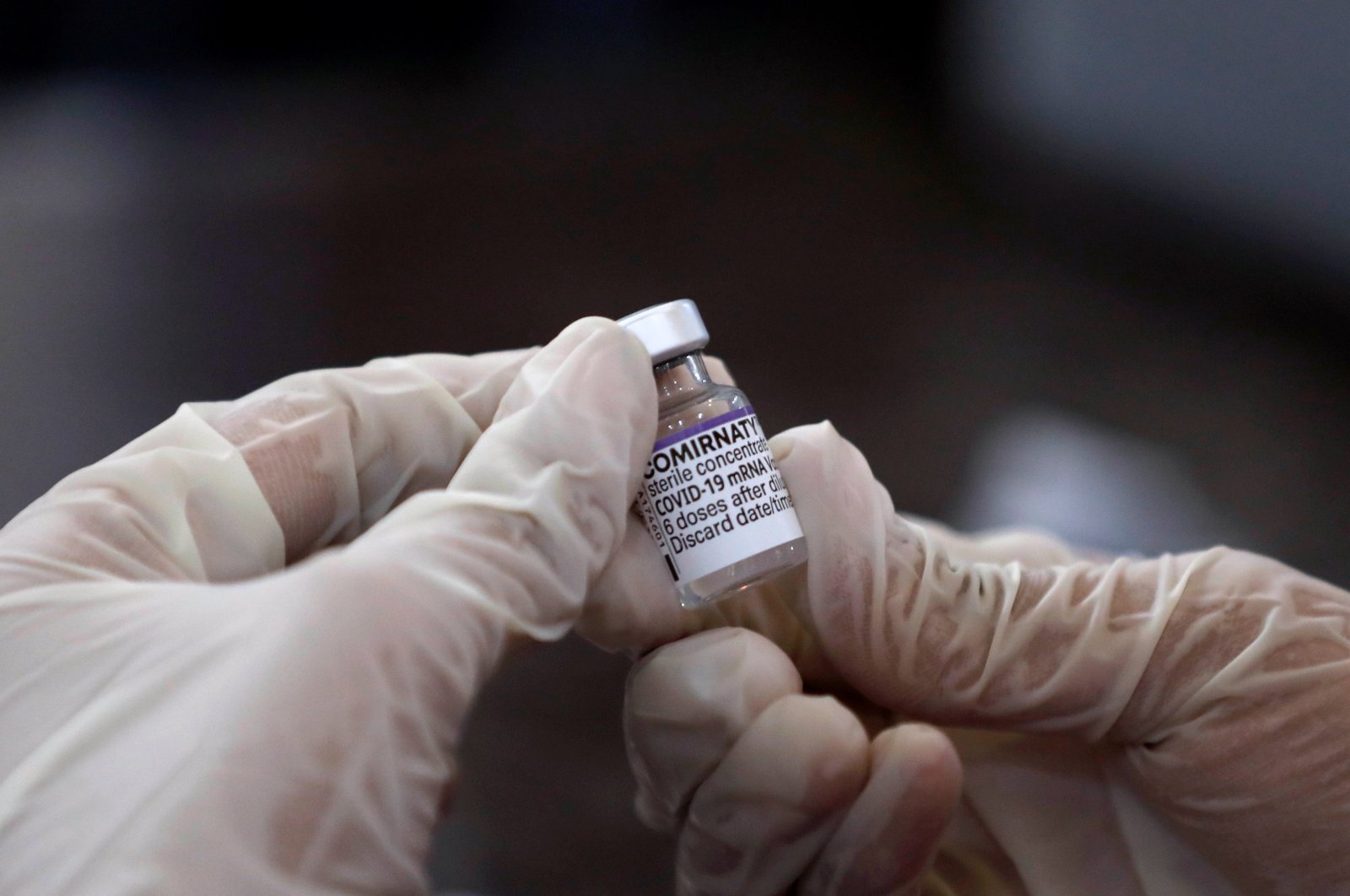 A health worker holds a vial of the &quot;Comirnaty,&quot; Pfizer-BioNTech&#039;s COVID-19 vaccine at a vaccination center in Karachi, Pakistan, Dec. 2, 2021. (Reuters Photo)