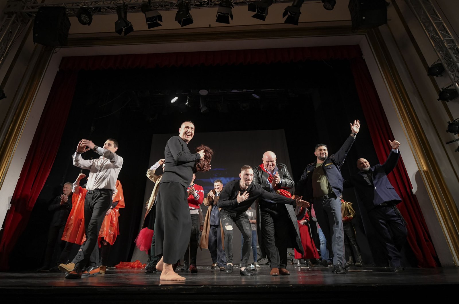 Inmates salute the public after performing in the “State of Siege,” by French author Albert Camus, a play describing a totalitarian Spanish regime during the plague, at the Nottara Theater in Bucharest, Romania, Nov. 24, 2021. (AP Photo)